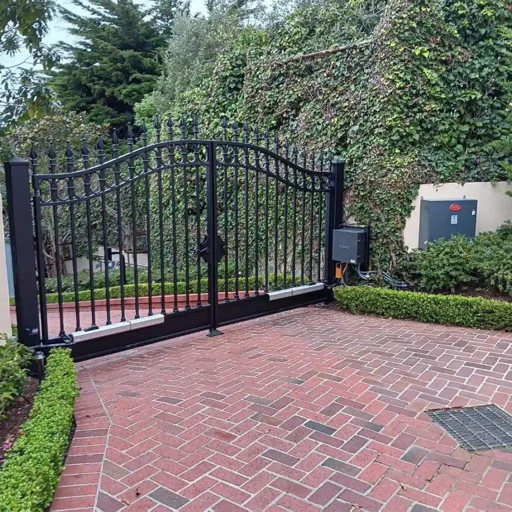 Photo Of A Modern Black Automatic Sliding Gate Installed Across A Gravel Driveway