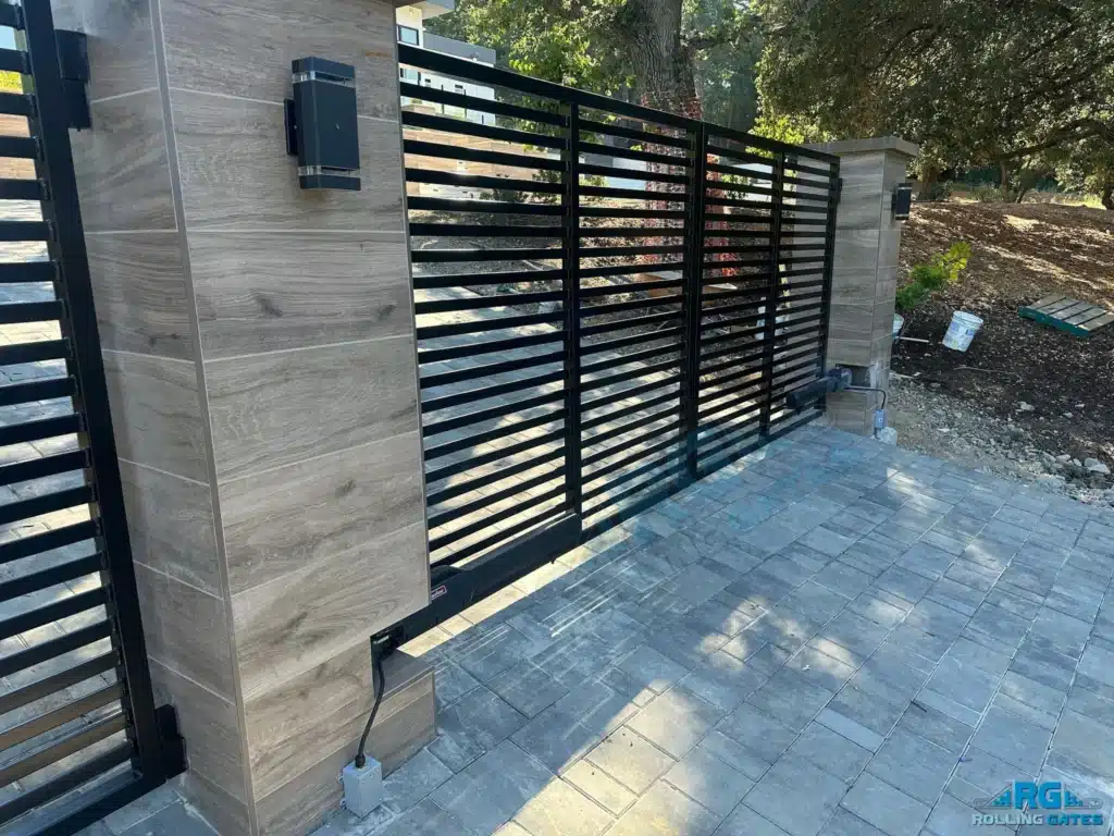 Photo Of An Elegant Arched Black Iron Double Swing Gate At A Brick Home Driveway Entrance