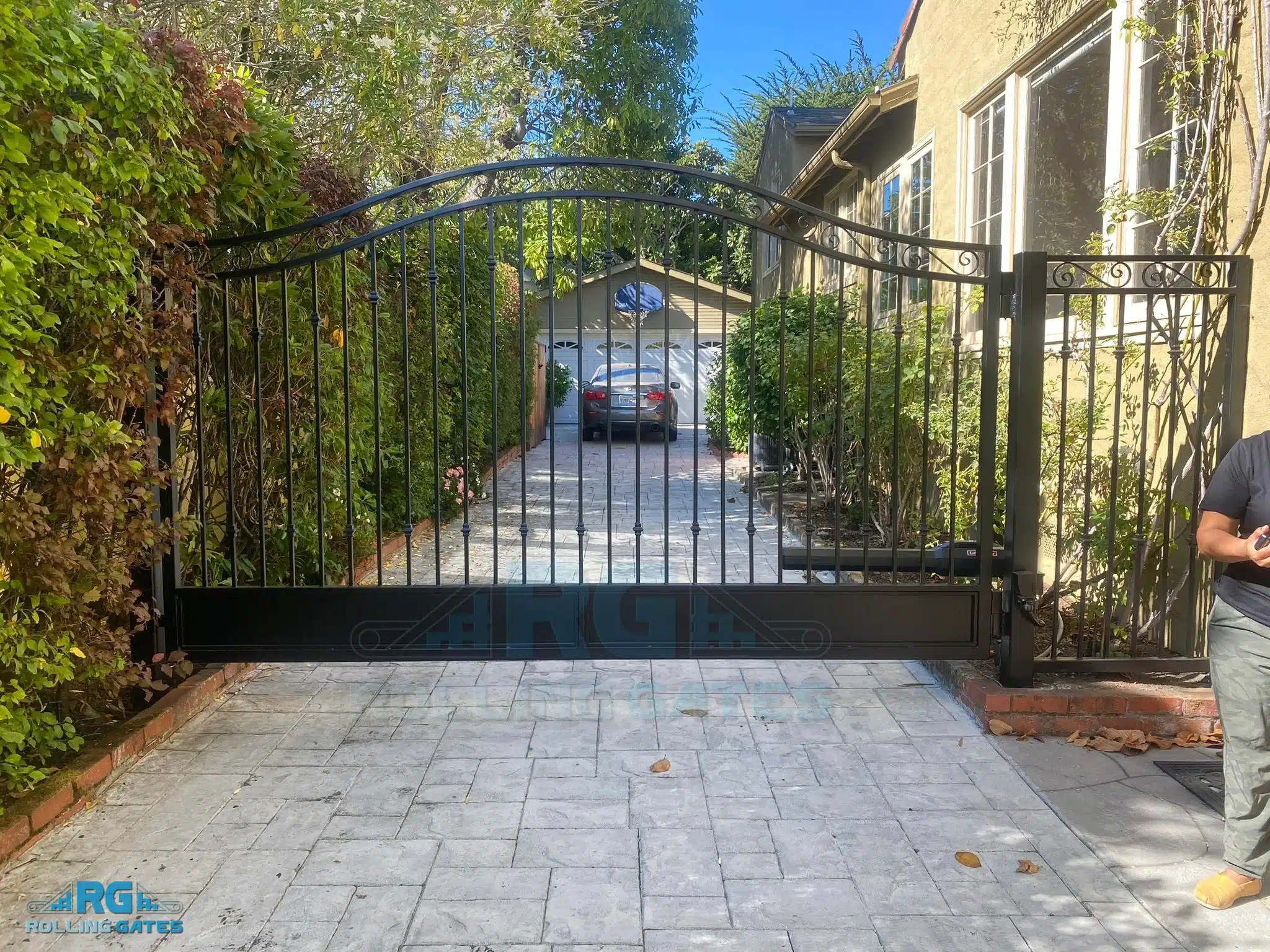 Photo Of Arched Black Metal Sliding Gate Illustrating Pros And Cons Of Automatic Driveway Gates