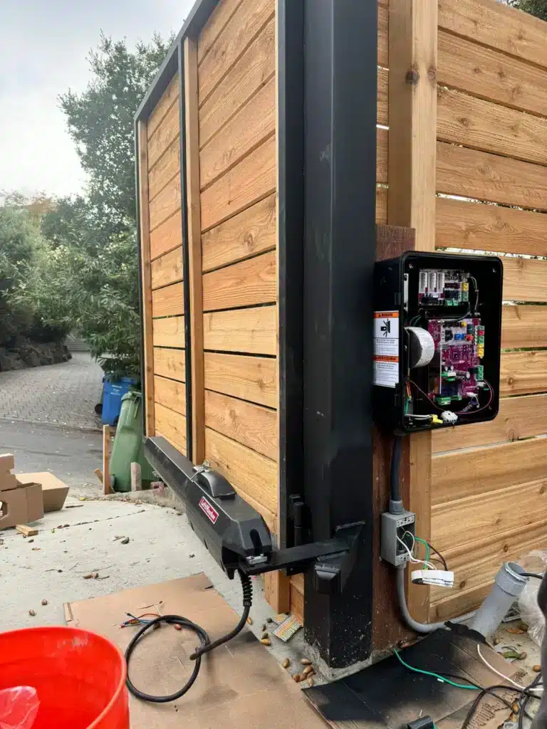 Photo Of Exposed Circuit Board And Swing Arm Motor Mounted On Wooden Gate