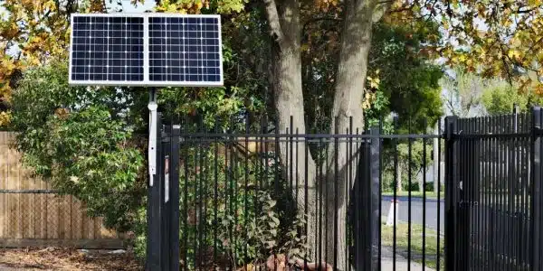 Photo Showing Difference Between Solar And Electric Gate Openers On Black Fence